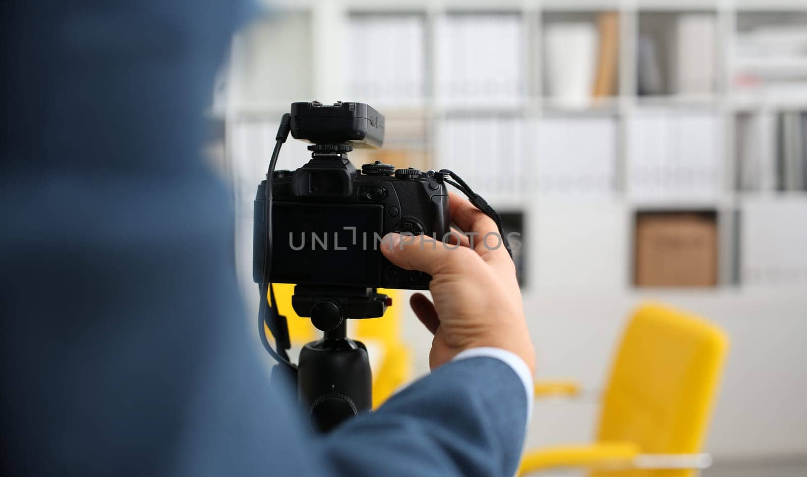 Male arms in suit mount camcorder to tripod making promo videoblog or photo session in office closeup. Vlogger adjust set up and check image quality to show job offer promotion selfie information