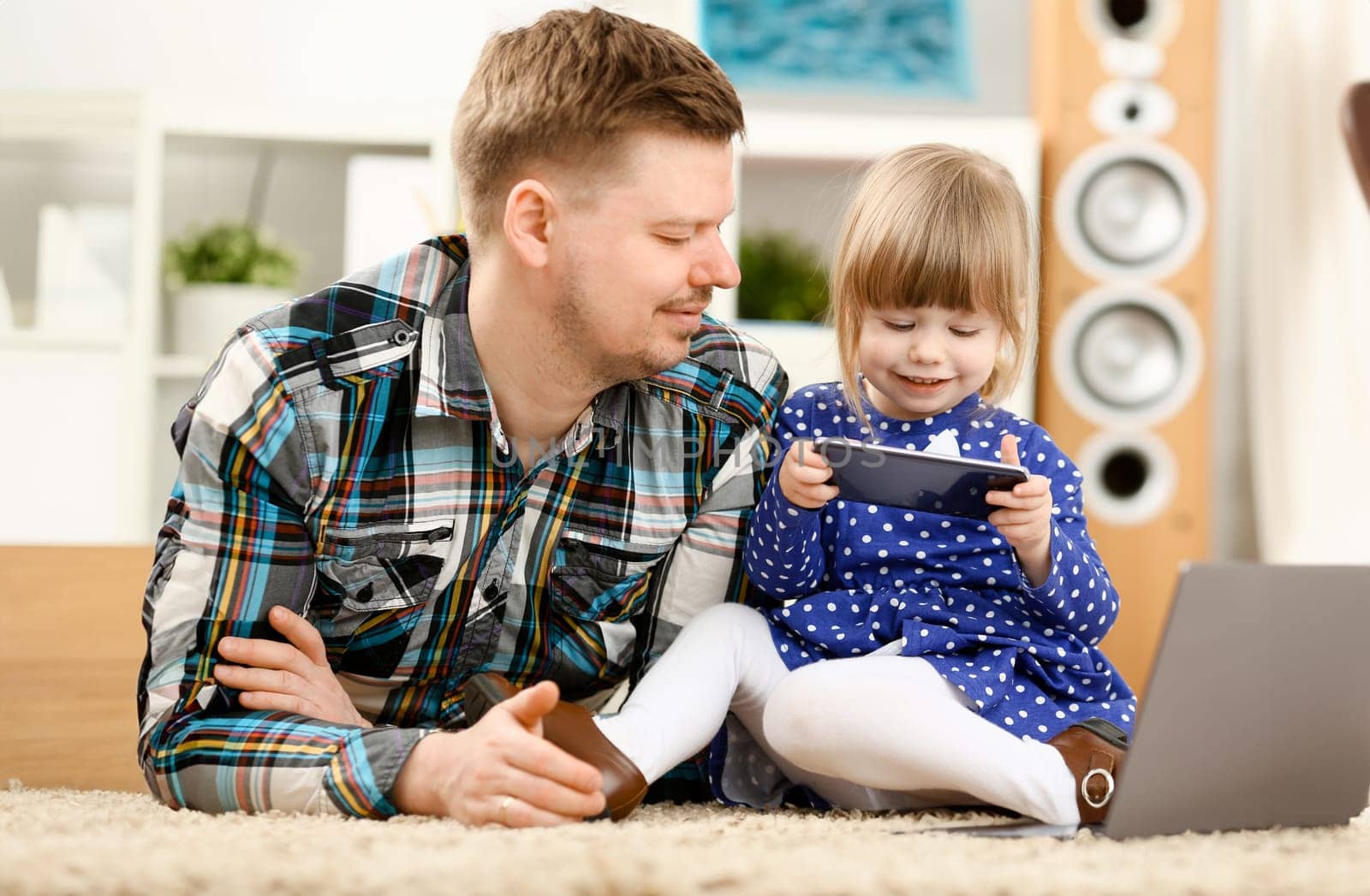 Cute little girl on floor carpet with dad use cellphone calling mom portrait. Life style apps social web network wireless ip telephony concept