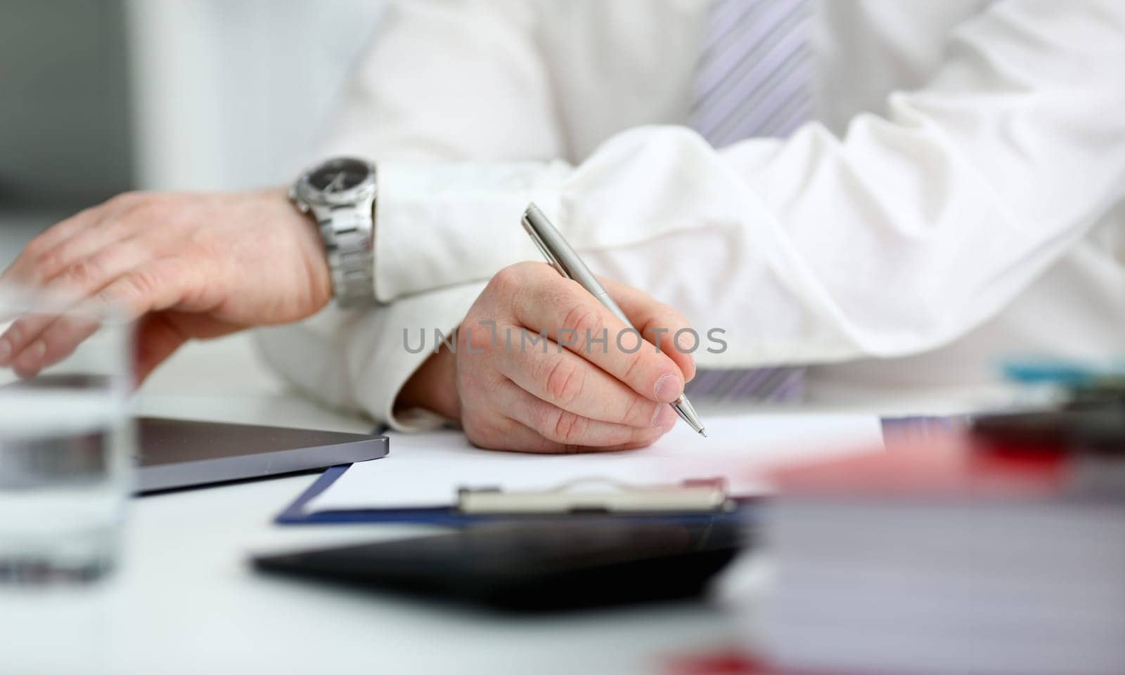 Male arm in suit and tie hold silver pen by kuprevich