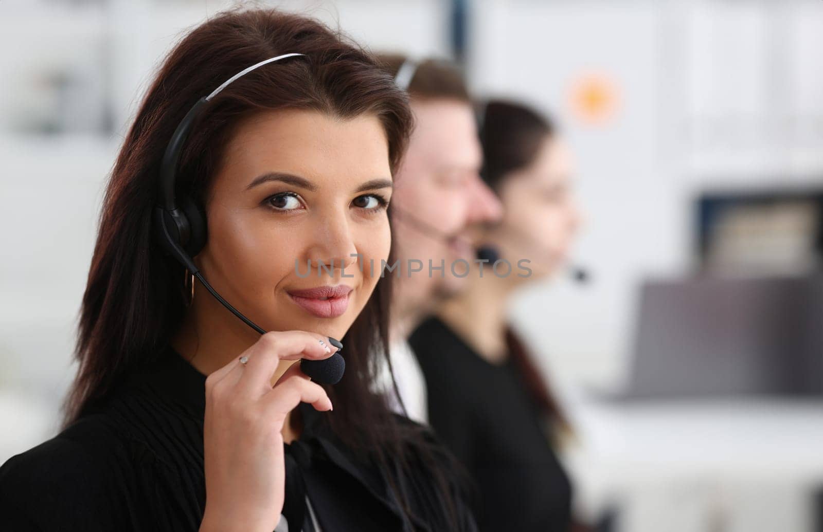 Three call centre service operators at work. Portrait of smiling pretty brunette woman at workplace employment effective mediation negotiation participation solve problem real time aid job concept