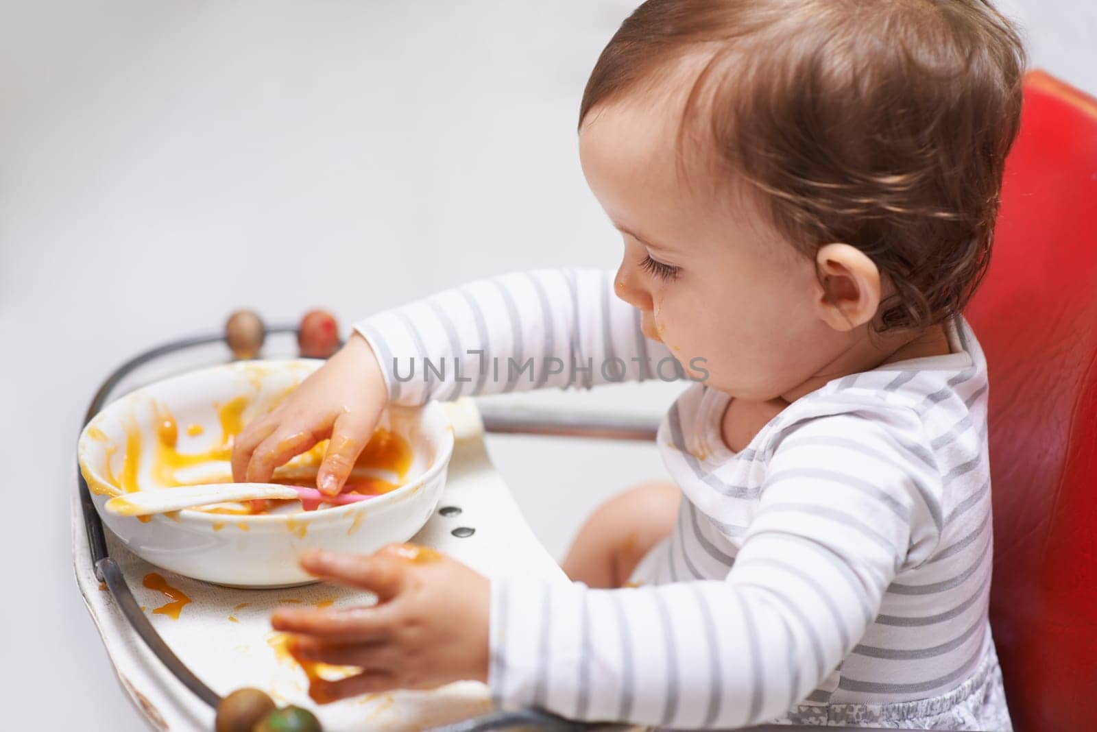 Eating, puree and girl baby in chair with vegetable food for child development at home. Cute, nutrition and hungry young kid or toddler enjoying healthy lunch, dinner or supper meal at house