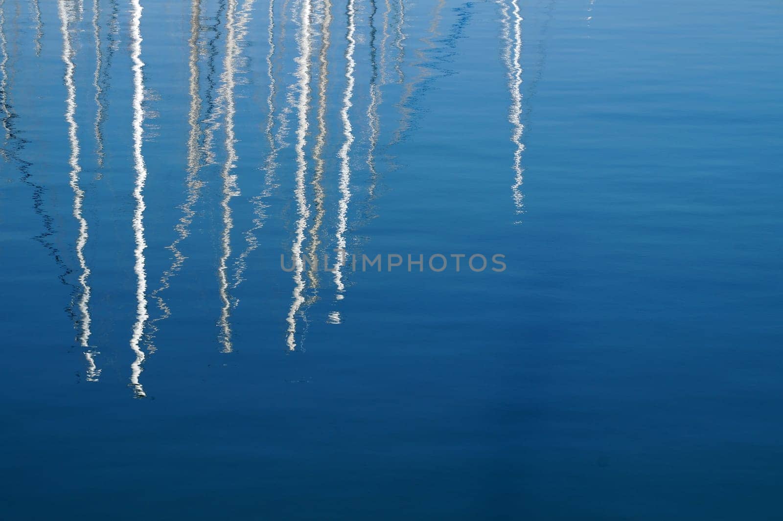 yachts match reflected in blue sea water by Annado