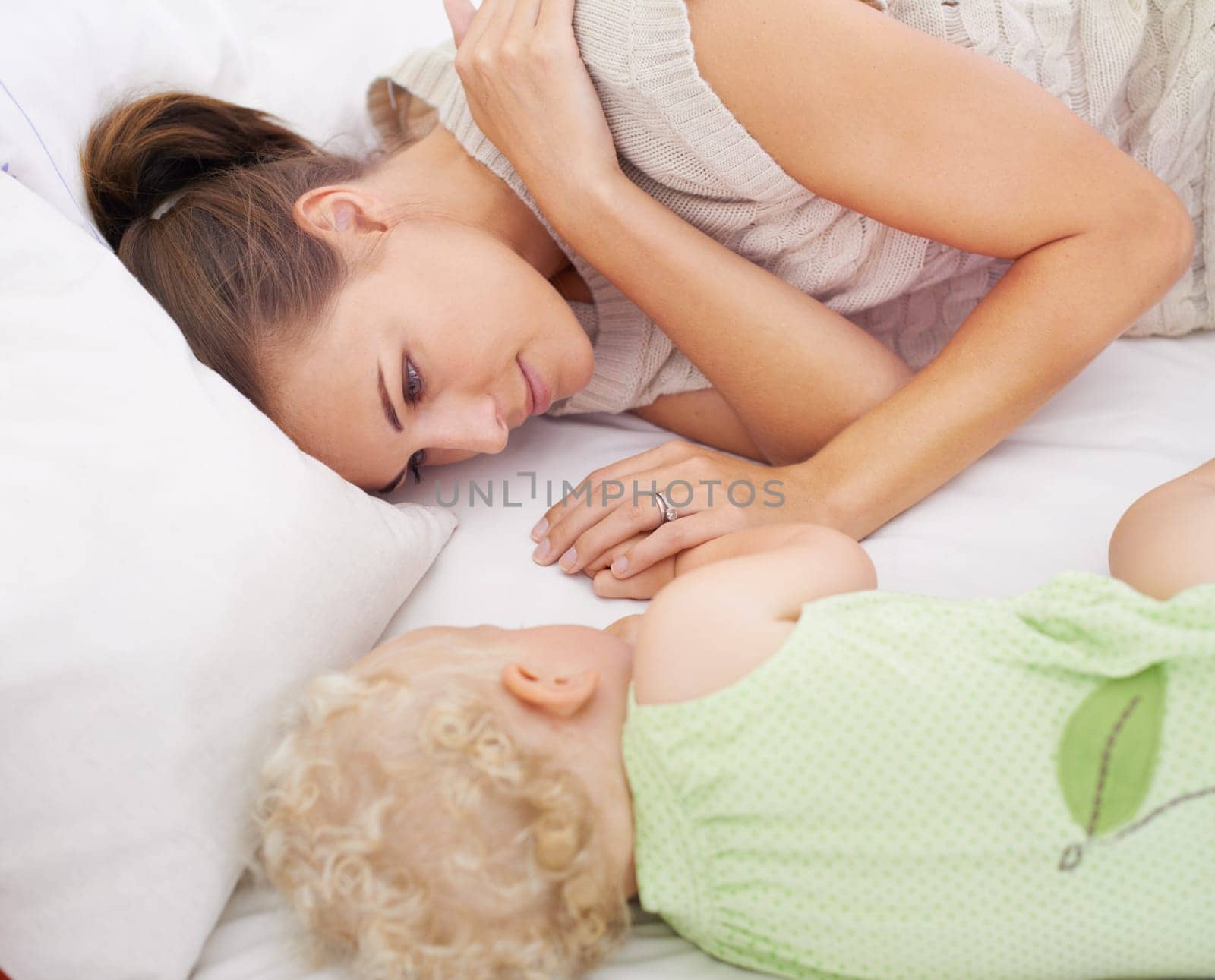 Bonding, sleeping and mom with baby on bed for dreaming, relax and happy cute family time. Love, smile and young mother watching girl child, kid or toddler taking a nap in bedroom or nursery at home.