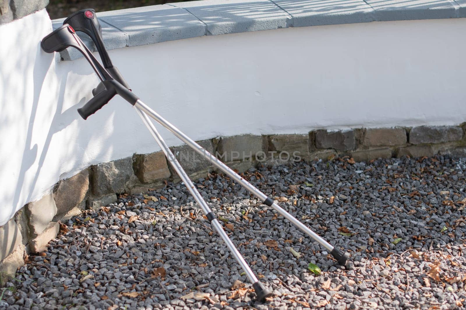 someone with a broken leg forgot his crutches at the fence and walked away on his own without support, concept of successful rehabilitation, high quality photo