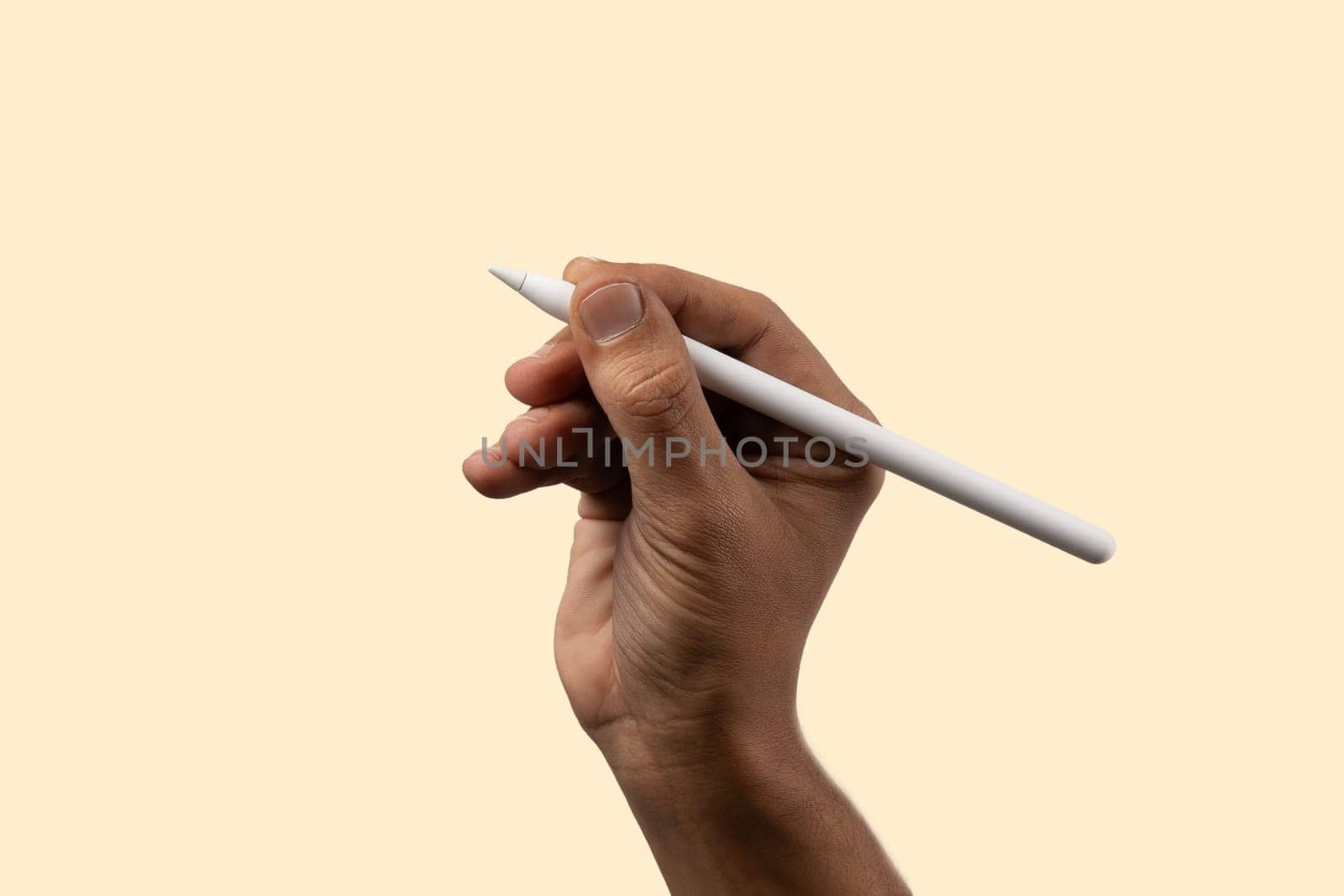 Black male hand holding smart pencil on light beige background, isolated. High quality photo