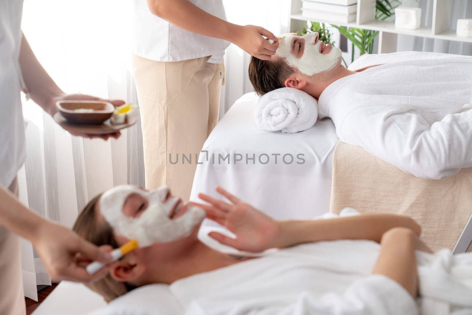 Serene ambiance of spa salon, couple indulges in rejuvenating with luxurious face cream massage with modern daylight. Facial skin treatment and beauty care concept. Quiescent