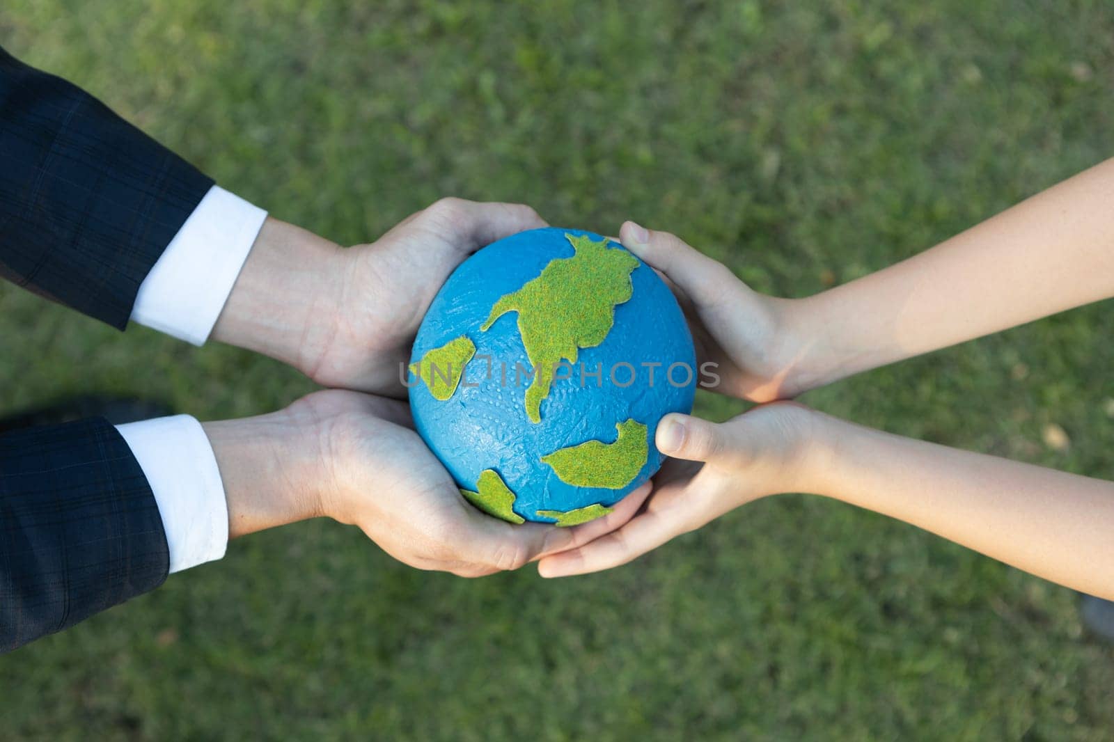 Top view businessman hand giving Earth globe to little boy as Earth day concept as corporate social responsible to contribute greener environmental protection for sustainable future generation. Gyre