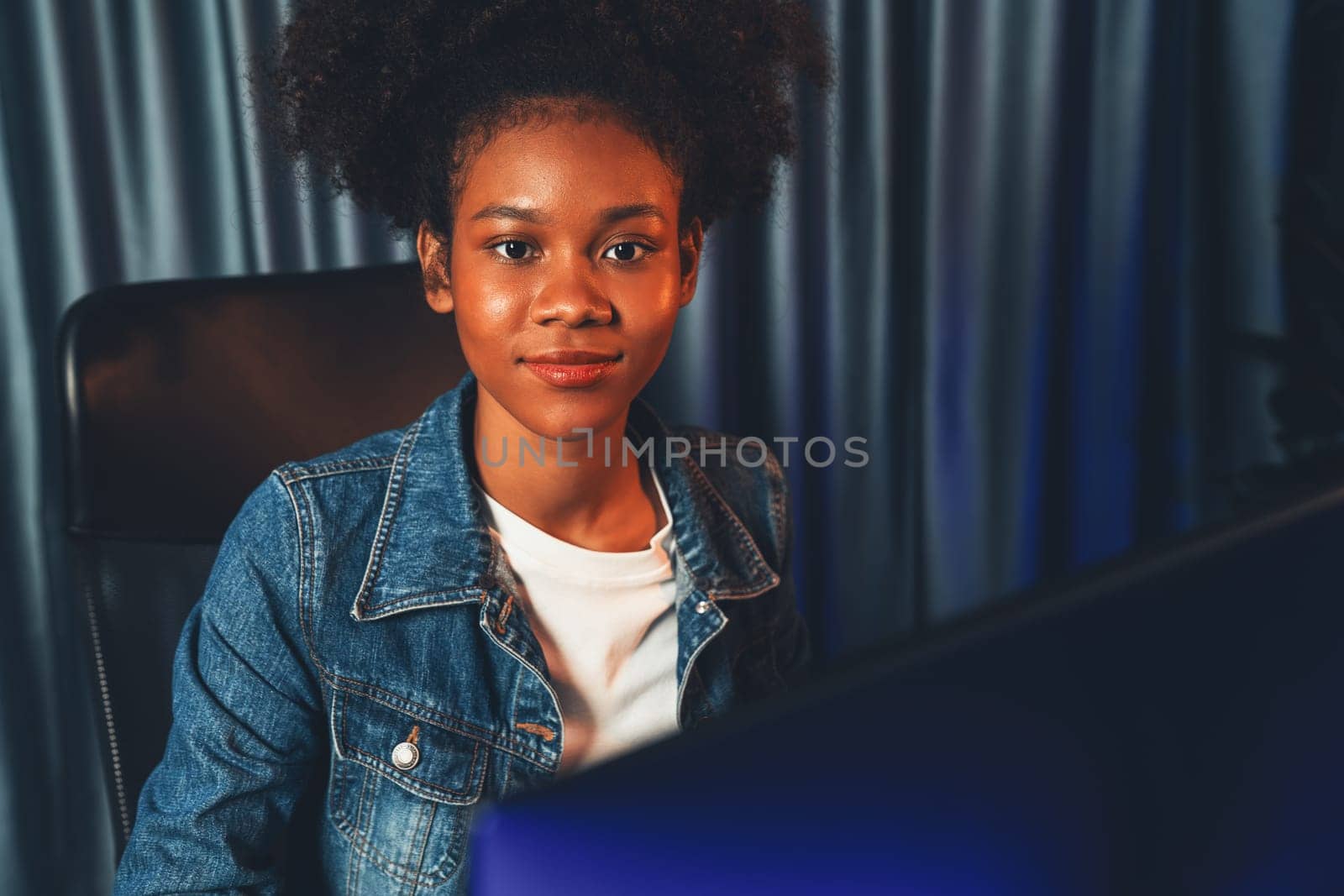 Young African American woman with surprise face, wearing blue jeans shirt and looking at final project document on laptop for planing next sequence. Concept of work at neat home place. Tastemaker.