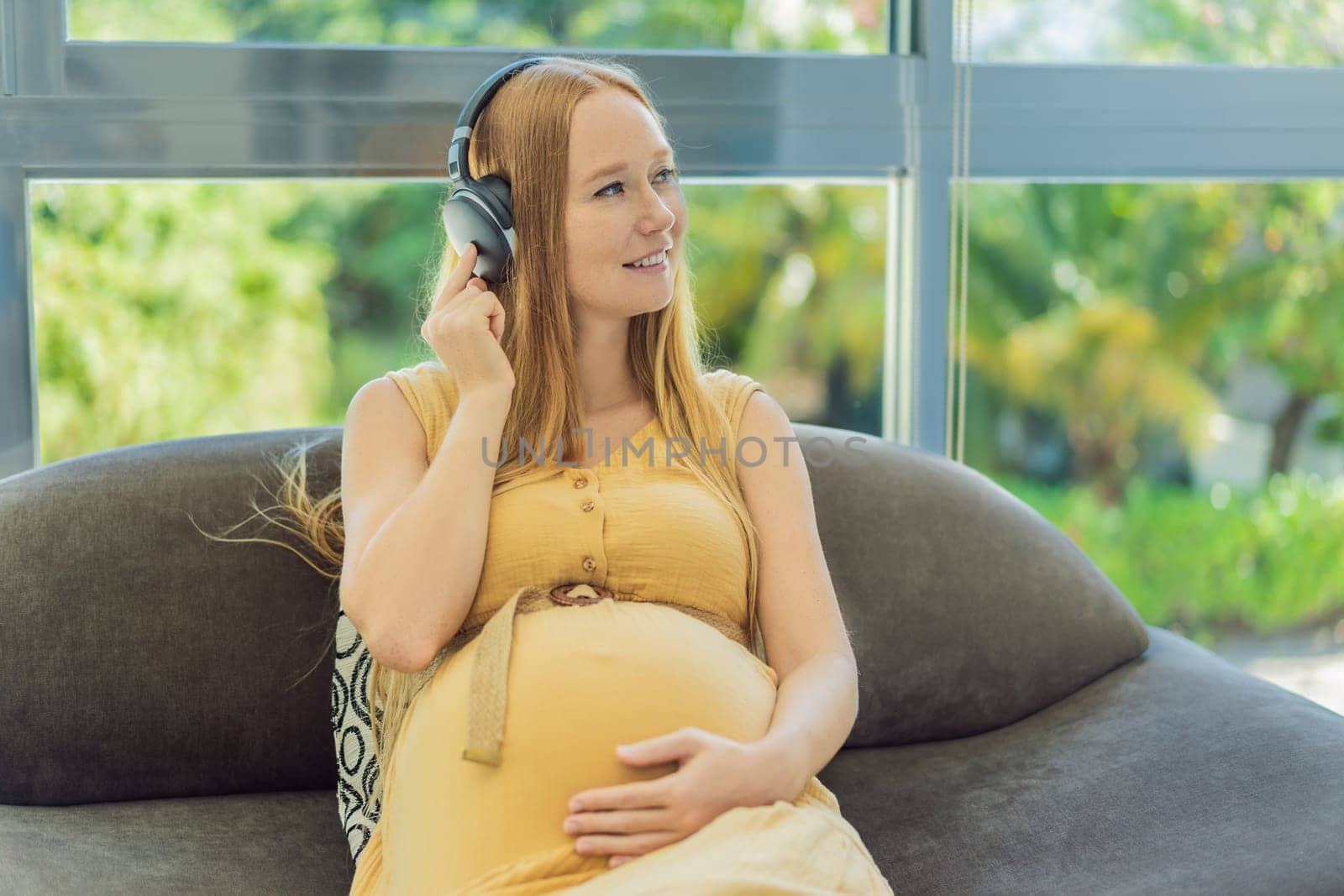 Expectant mom finds joy in her pregnancy, listening to soothing music for a serene and harmonious connection with her unborn baby by galitskaya