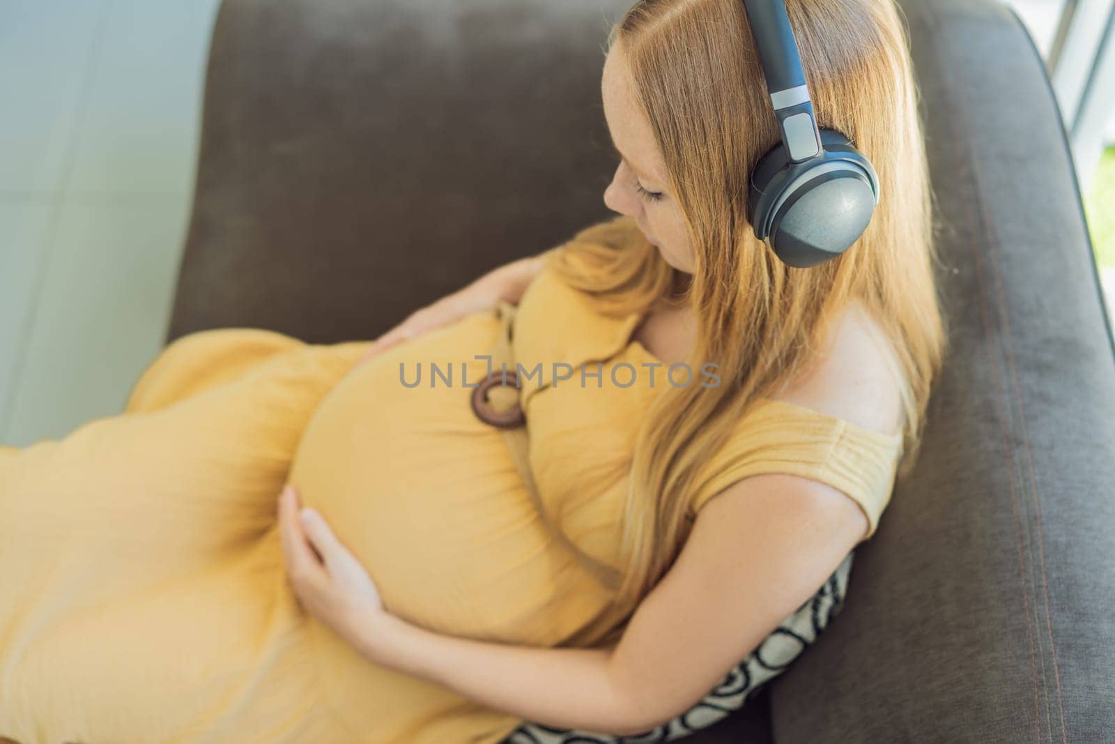 Expectant mom finds joy in her pregnancy, listening to soothing music for a serene and harmonious connection with her unborn baby by galitskaya