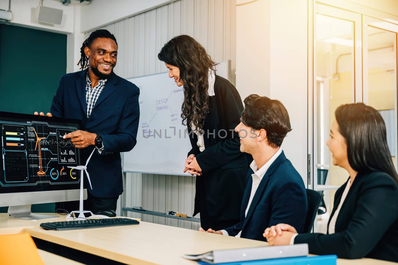 In a modern office, diverse colleagues demonstrate teamwork on a startup project. Three people analyze data on a computer, fostering discussion and leadership.