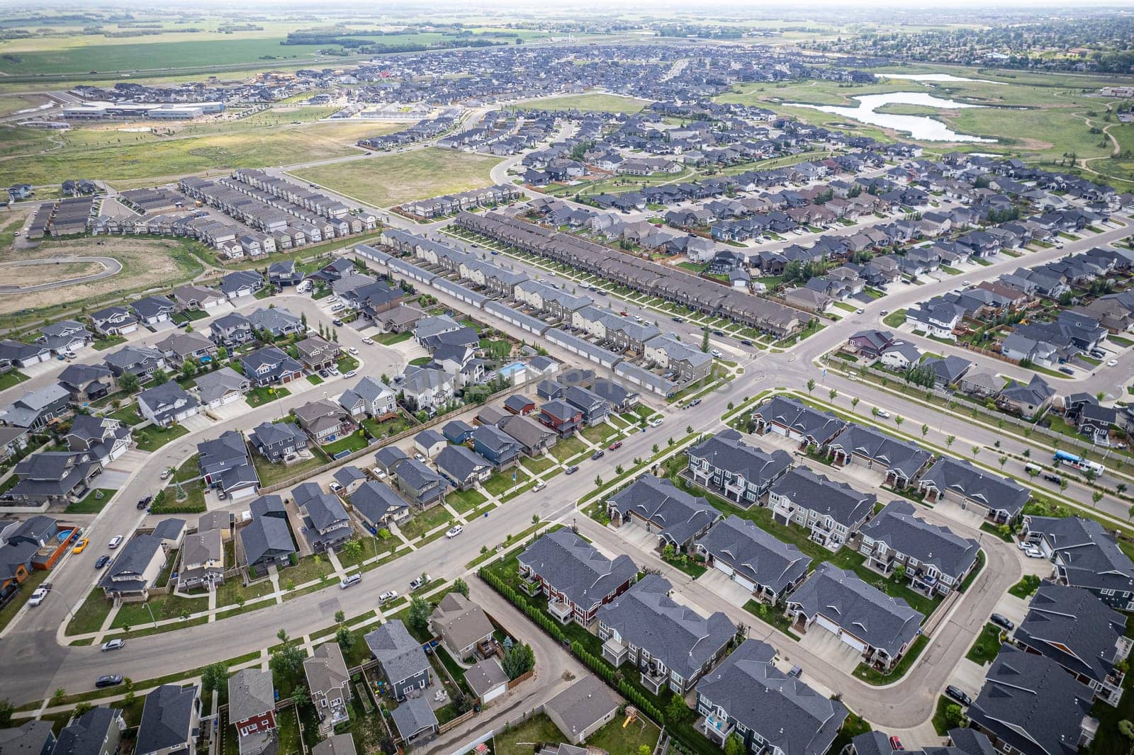 Elevated drone view of Rosewood, Saskatoon, showcasing its residential layout, green areas, and vibrant community life.