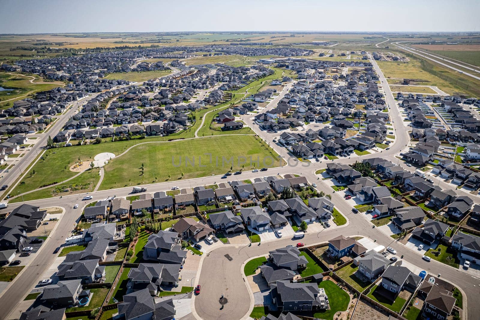 Elevated drone view of Rosewood, Saskatoon, showcasing its residential layout, green areas, and vibrant community life.