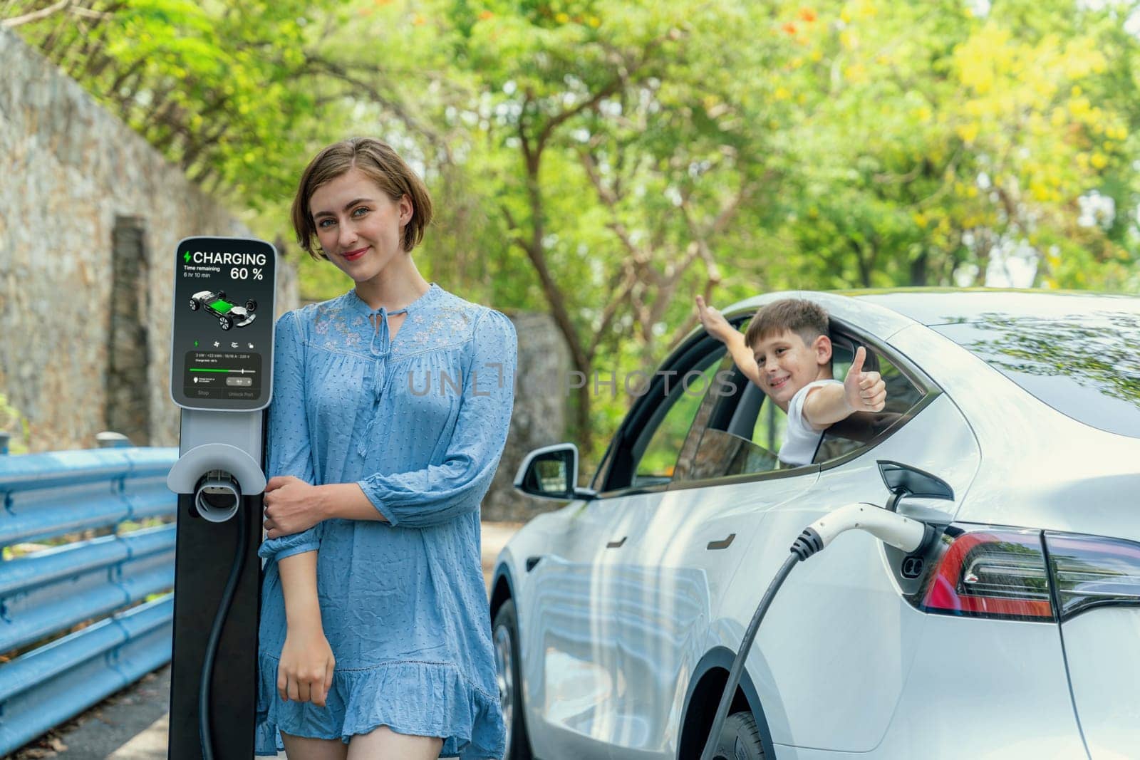 Family road trip vacation with electric vehicle, mother and son recharge EV car with green and clean energy. Nature and travel with eco-friendly car for sustainable environment. Perpetual