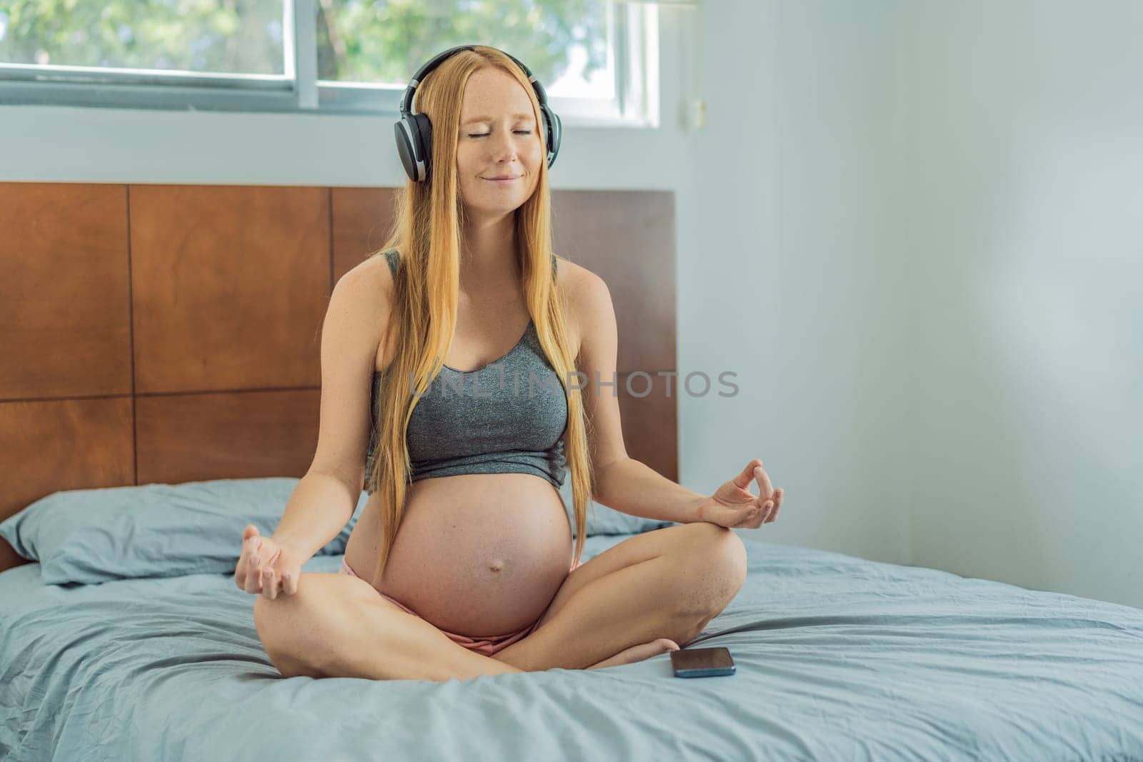 Expectant woman finds serenity in pregnancy, listening to affirmations and meditating for calmness by galitskaya