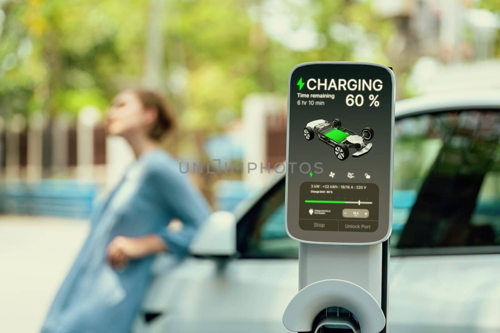 Electric vehicle recharging battery from home EV charging station using alternative energy with net zero emission on blurred background of young girl charging her car before vacation travel. Perpetual