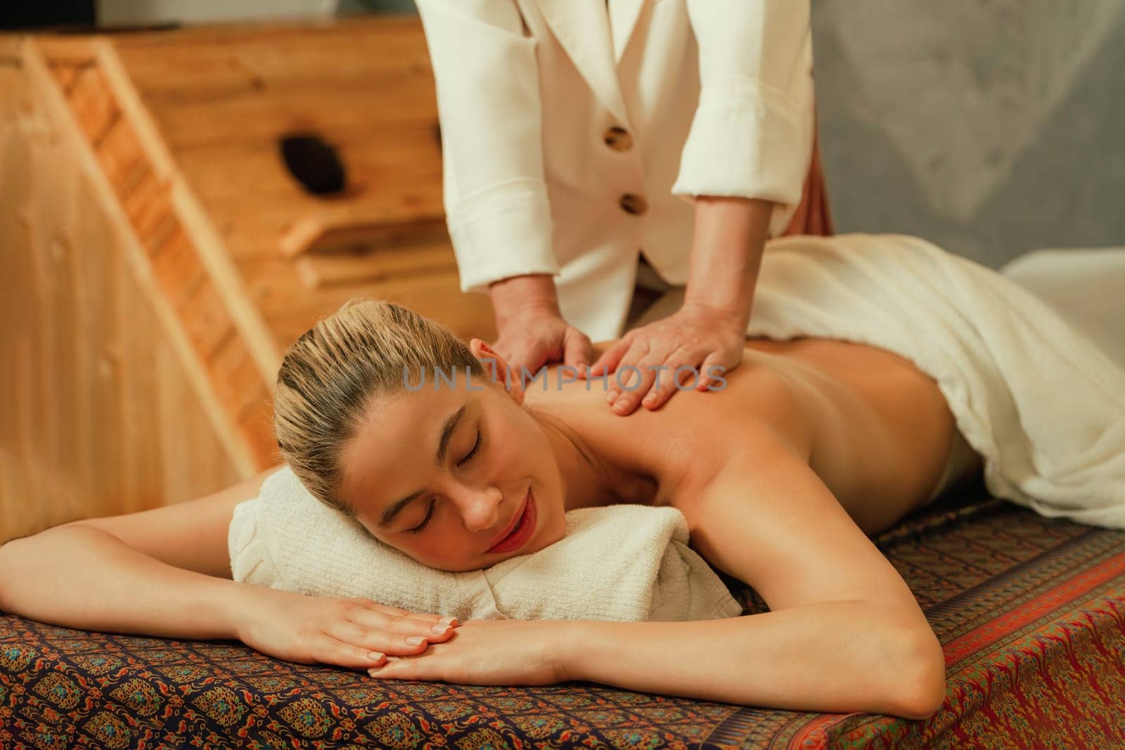 Beautiful woman having back massage in front of sauna cabinet. Tranquility. by biancoblue