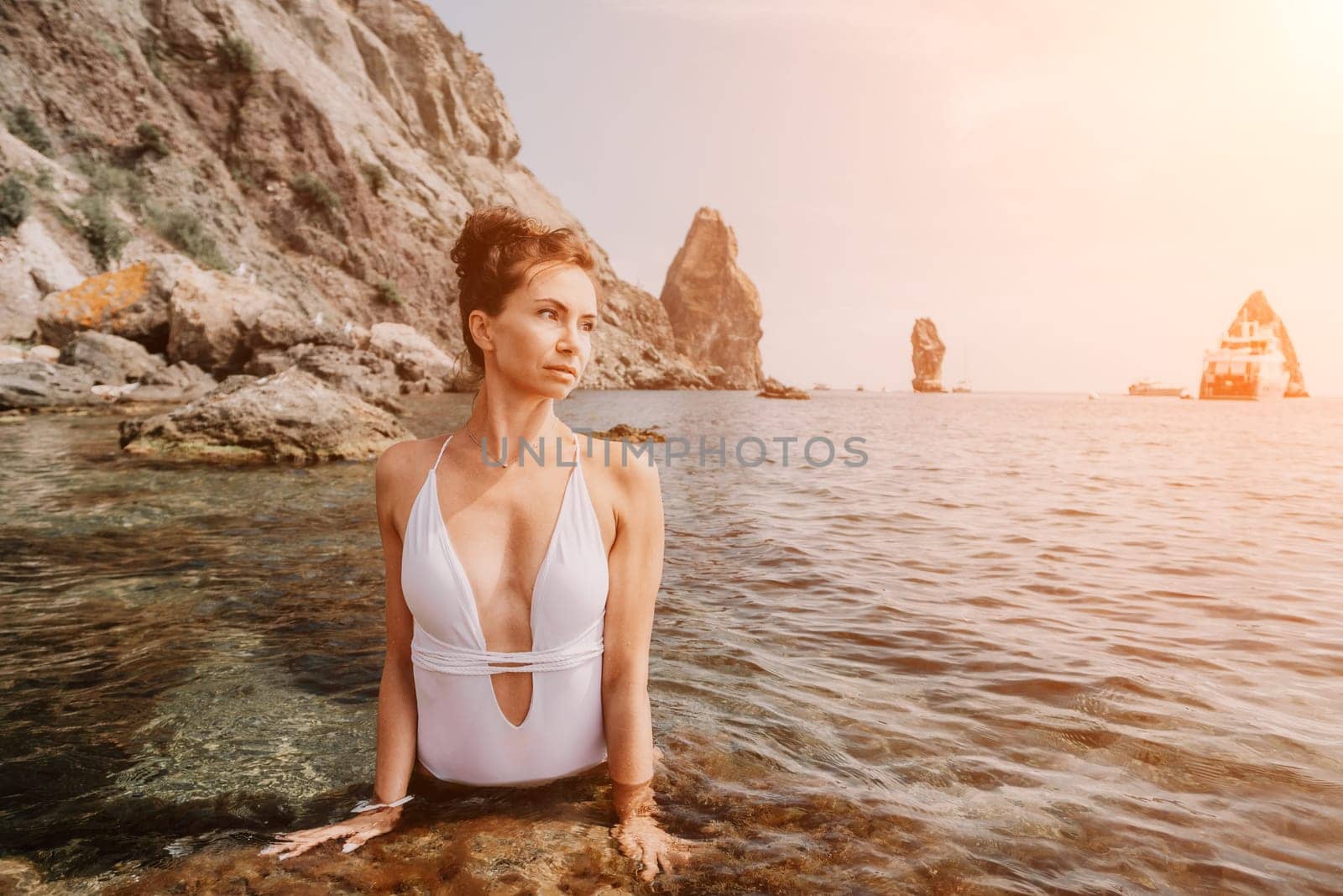 Woman sea fitness. Happy woman in a white bikini performing pilates in the sea on the beach. Female fitness yoga routine concept. Healthy lifestyle. by panophotograph