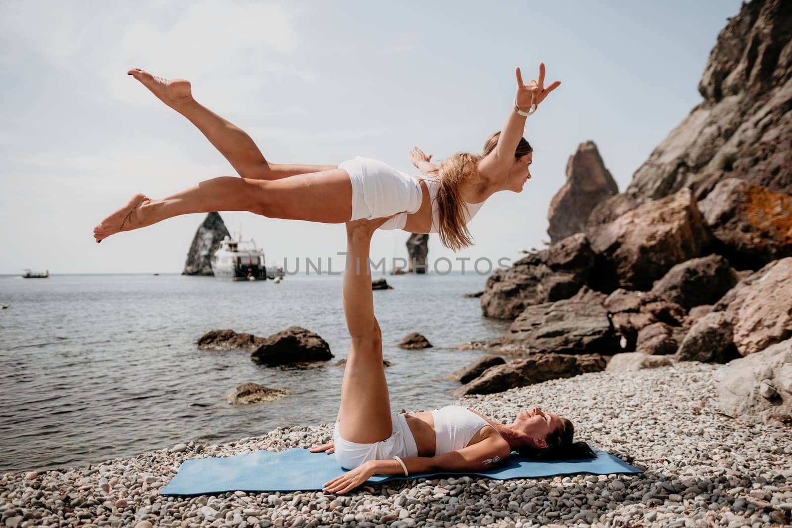 Woman sea yoga. Back view of free calm happy satisfied woman with long hair standing on top rock with yoga position against of sky by the sea. Healthy lifestyle outdoors in nature, fitness concept.