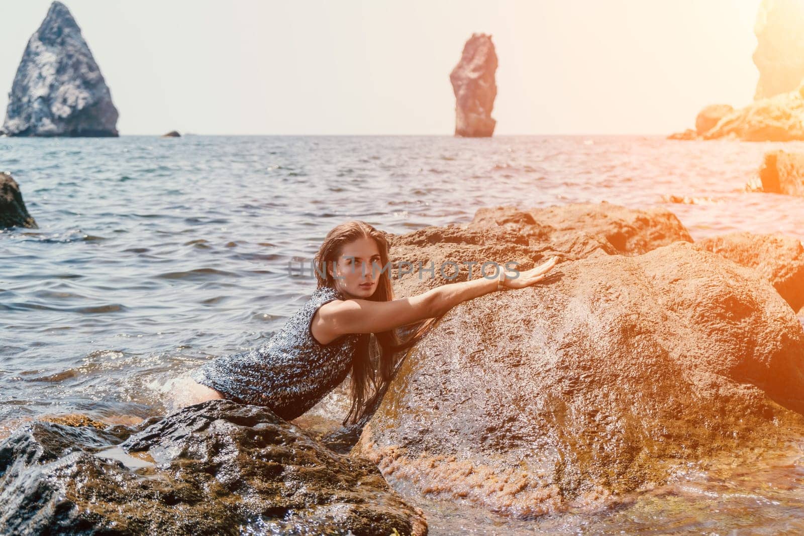 Woman summer travel sea. Happy tourist enjoy taking picture outdoors for memories. Woman traveler posing on the beach at sea surrounded by volcanic mountains, sharing travel adventure journey by panophotograph