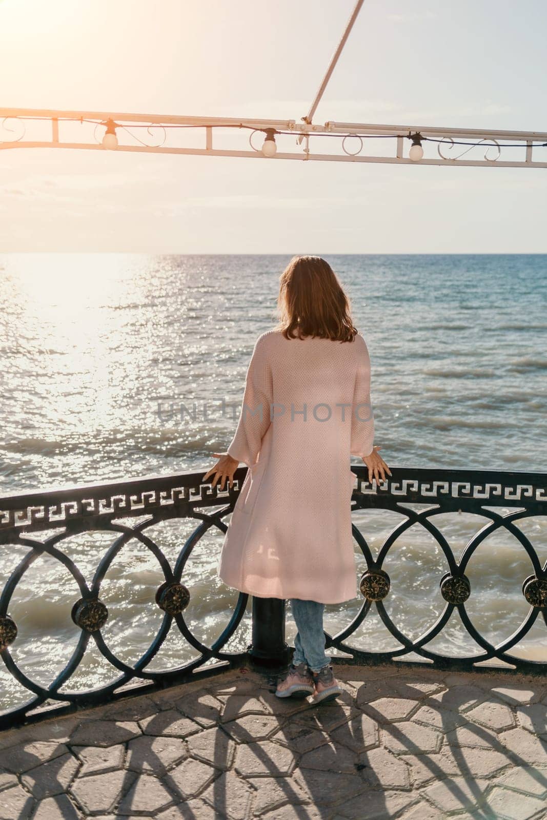 Woman summer travel sea. Happy tourist enjoy taking picture outdoors for memories. Carefree woman traveler posing on beach at sea on sunset, sharing travel adventure journey. Holiday vacation concept. by panophotograph