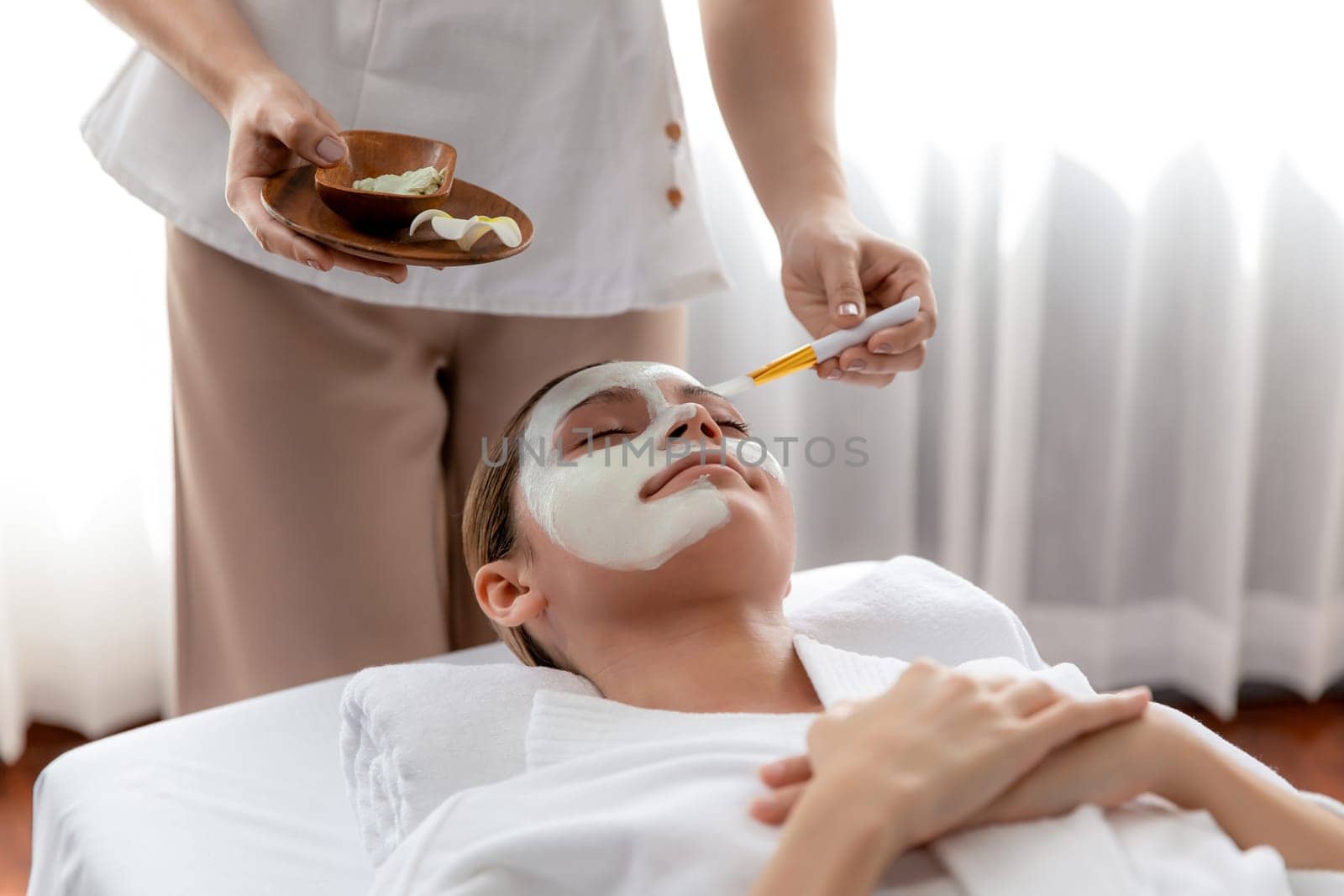 Woman indulges in rejuvenating with luxurious face cream spa massage. Quiescent by biancoblue