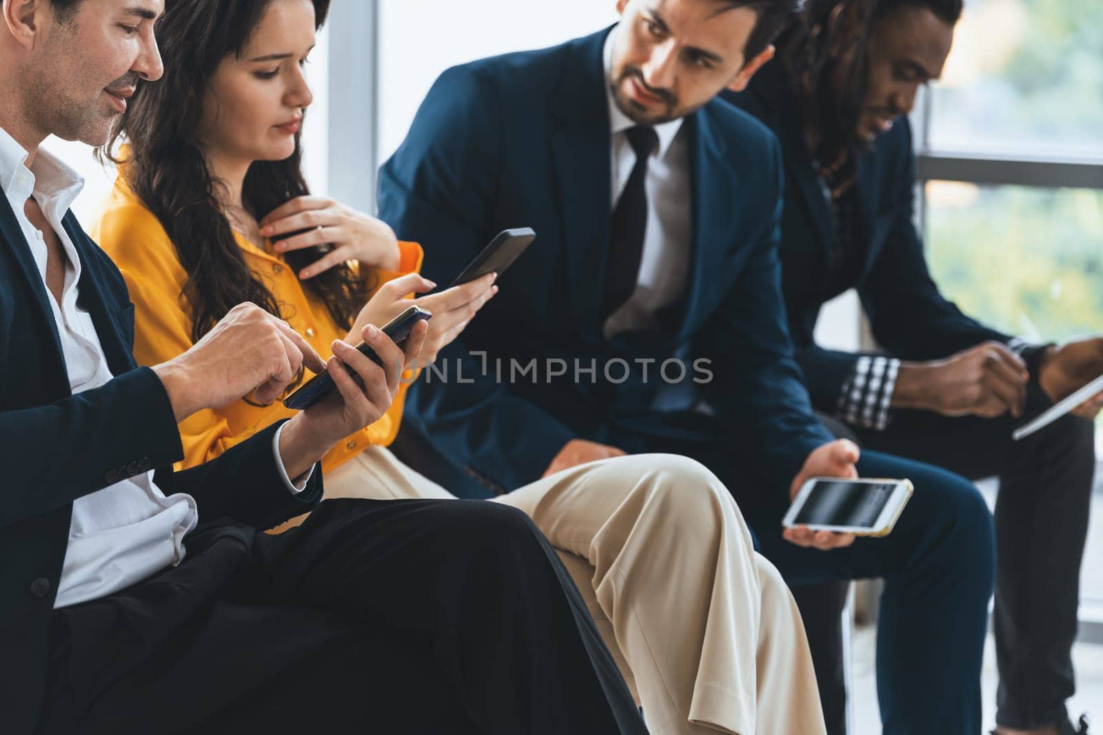 A group of diversity businessman sitting while sharing their data by using smart phone in side view. Smart businesswoman negotiating about finance information with handsome manager. Intellectual.