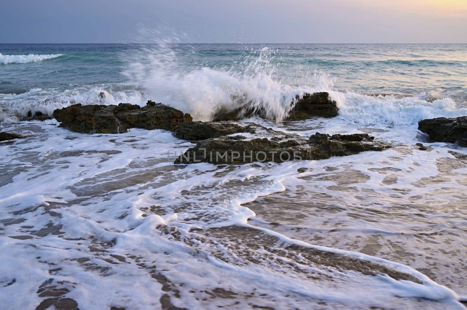 Sea at sunset with waves on the beach. Greece - the island of Corfu. by Montypeter