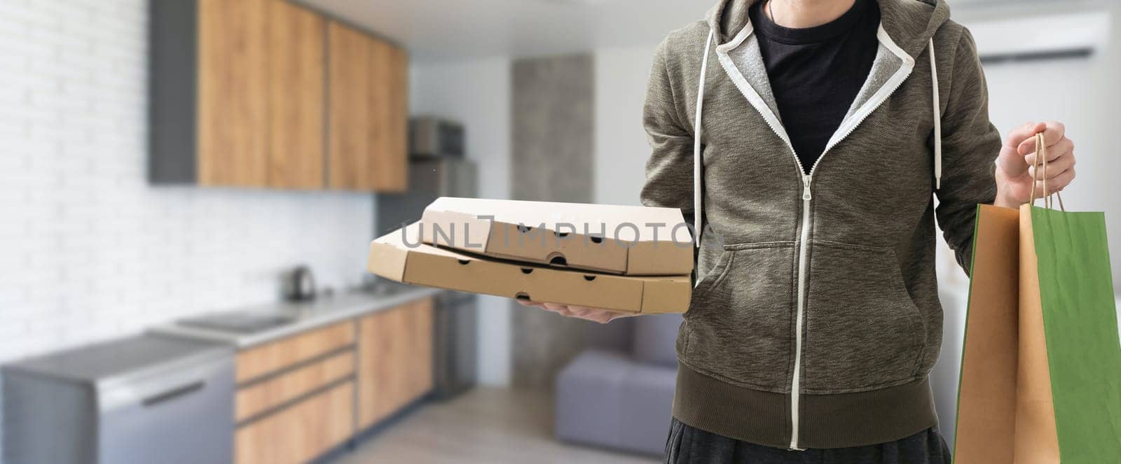 Young handsome delivery man holding paper bag with takeaway food happy with big smile