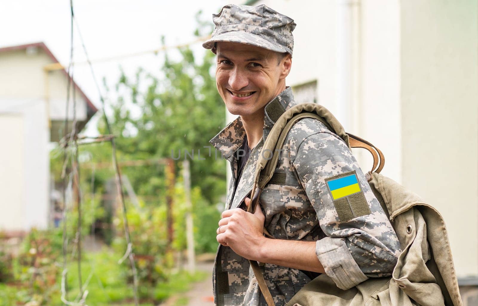 Ukrainian soldier wearing military uniform with flag and chevron depicting trident - Ukrainian national symbol flag by Andelov13