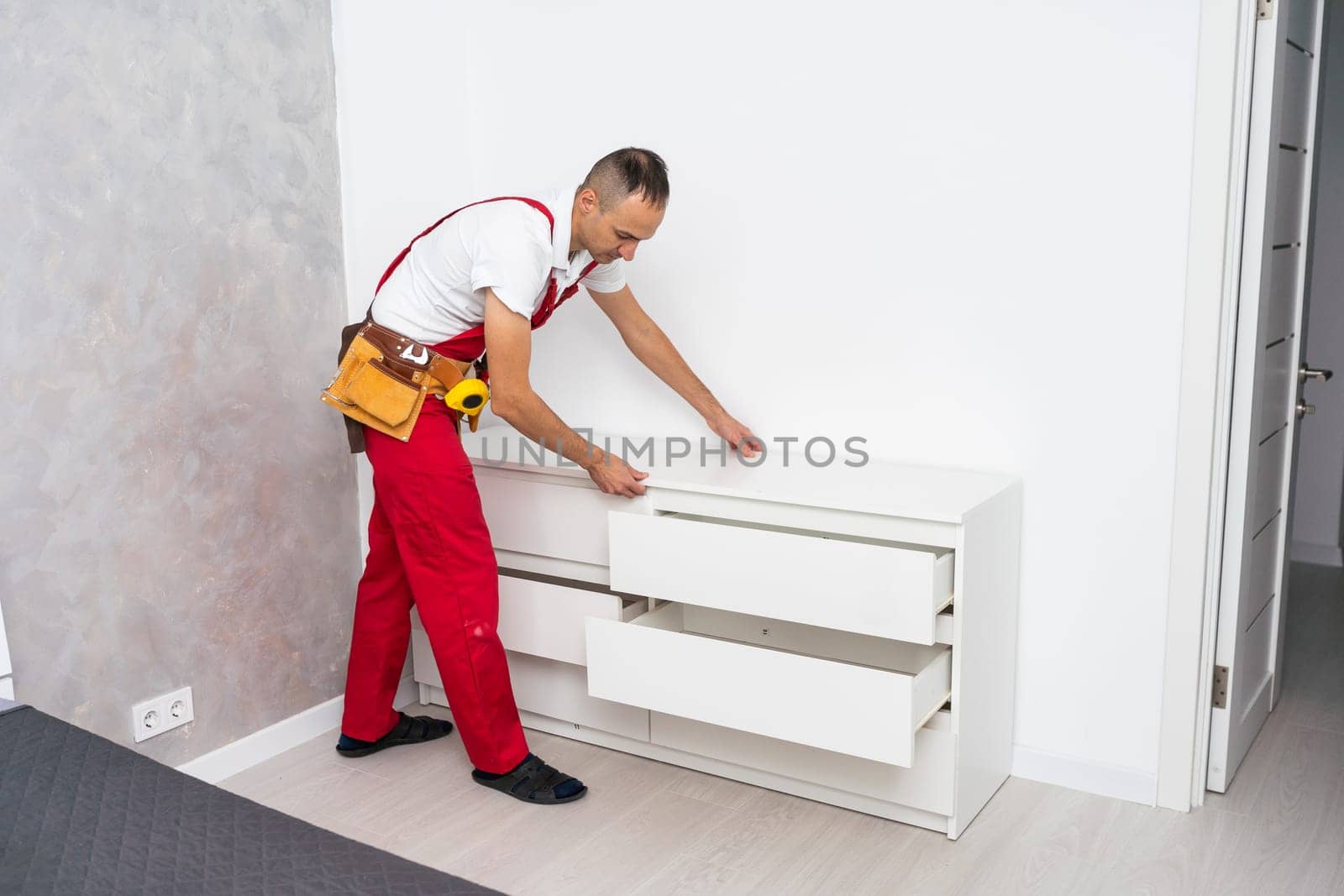 Professional furniture assembly and repair concept. Contractor repairman assembling furniture, indoors by Andelov13