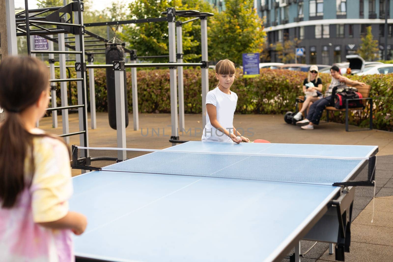 Little children playing ping pong in park. High quality photo