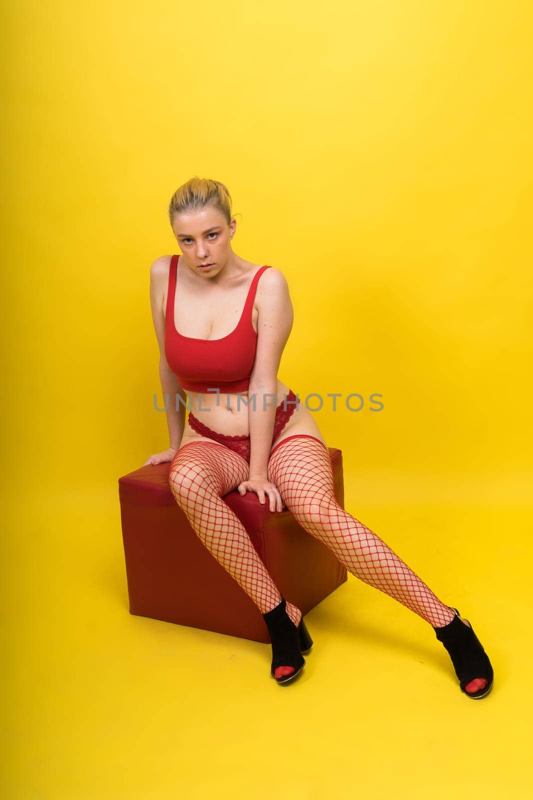 Seductive attractive blonde woman posing in fashionable lingerie in studio by Zelenin