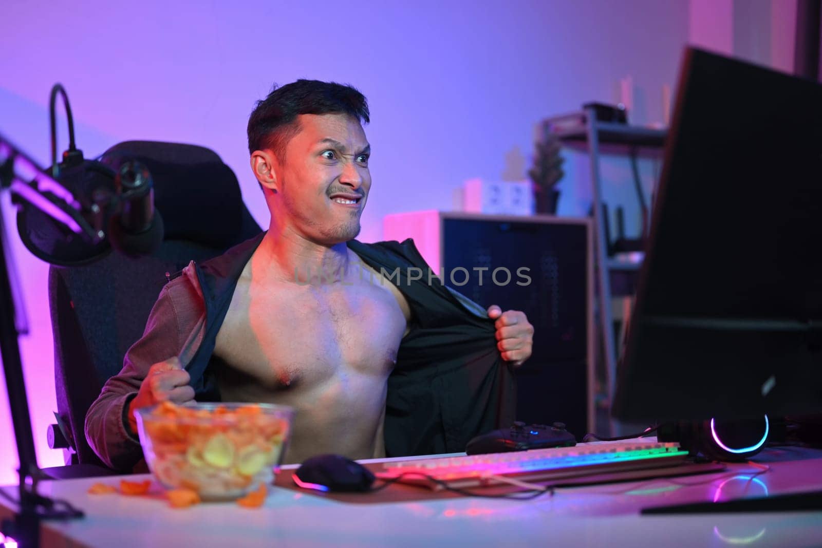 Aroused man watching pornographic sexual content on internet at night with pervert face expression