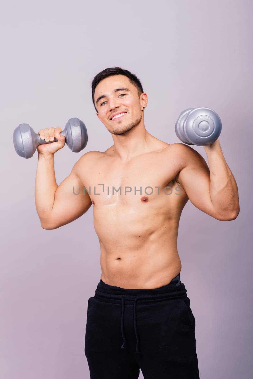 Portrait young fitness sporty strong man barechested muscular sportsman isolated on grey dark.