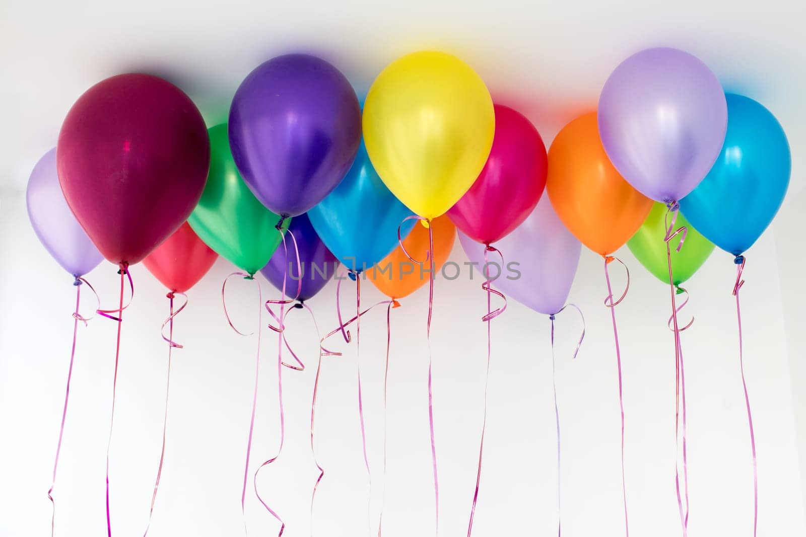 Bright colorful balloons fly under ceiling by Demkat