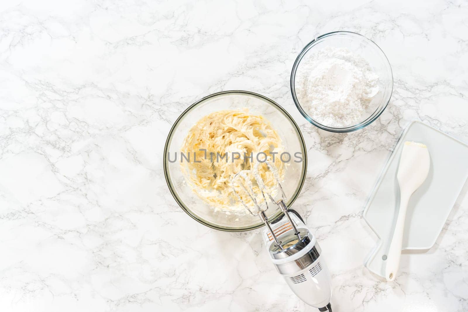 Flat lay. Creating a delectable treat, the process of making homemade cream cheese frosting involves whisking together creamy ingredients to achieve the perfect texture and taste.