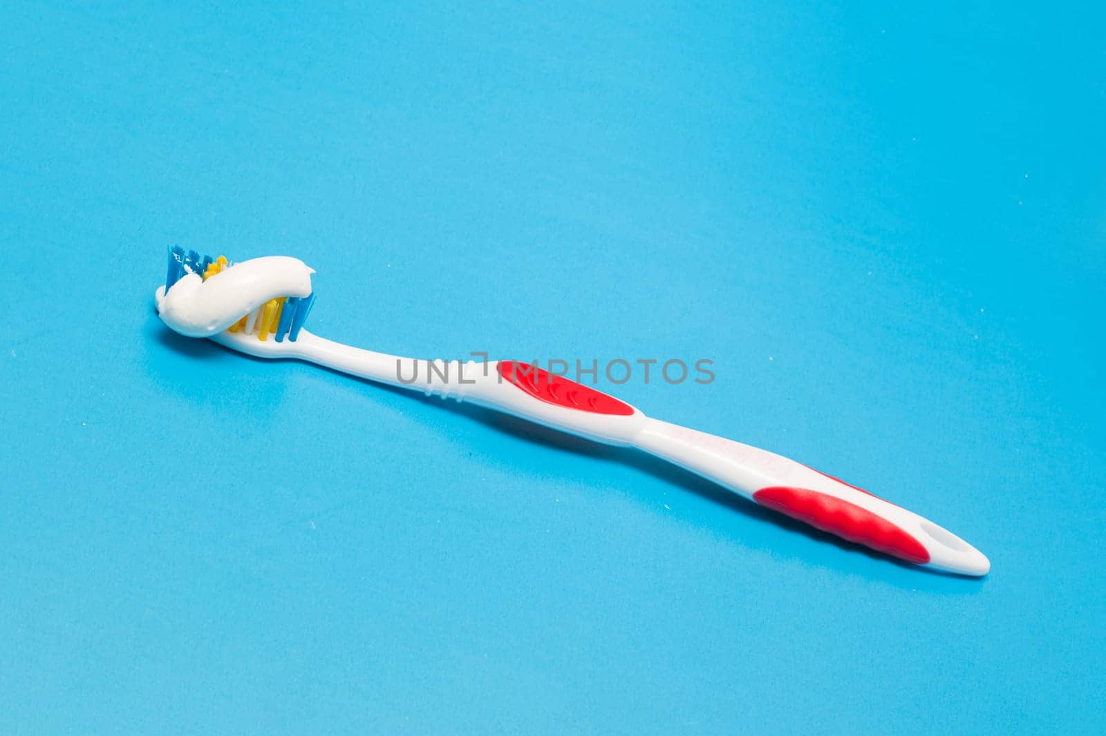 Toothbrush and toothpaste on a blue background close up