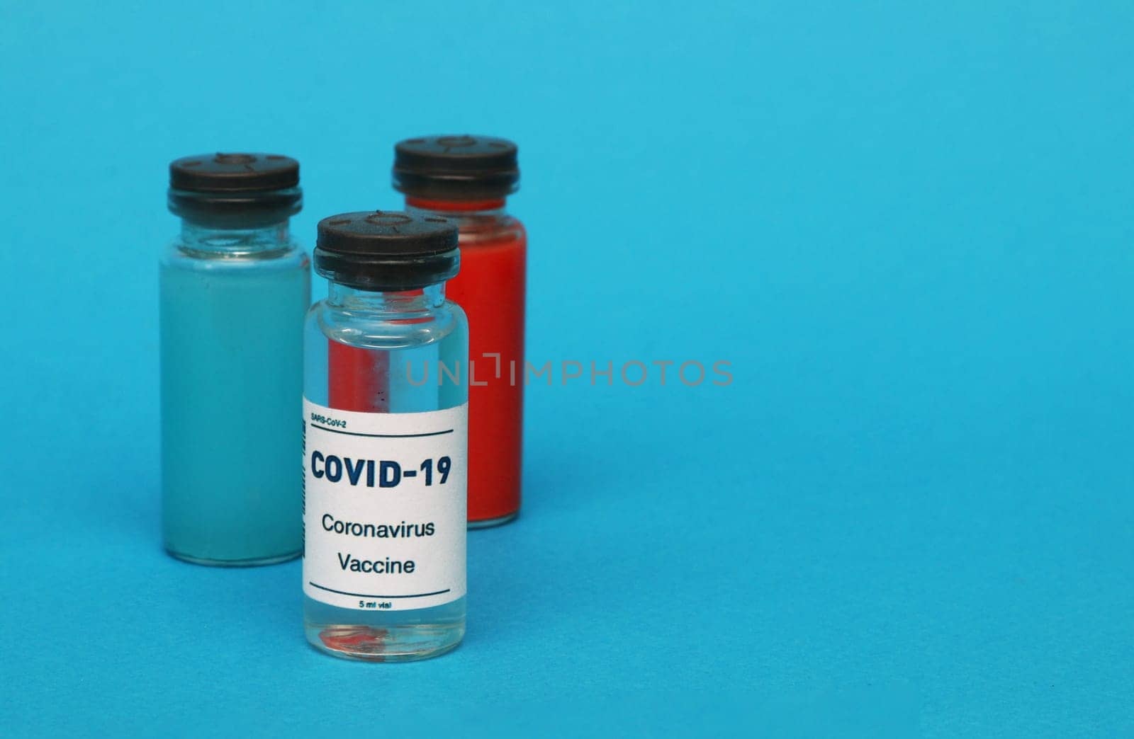 Glass bottle with covid-19 vaccine, blood bottle, blue liquid bottle. pharmaceutical concept.