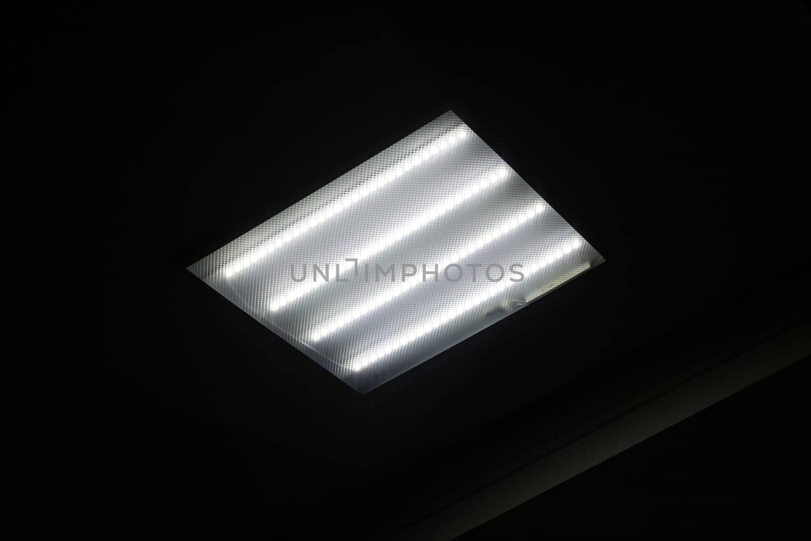 Square fluorescent lamp on the ceiling in the dark close up