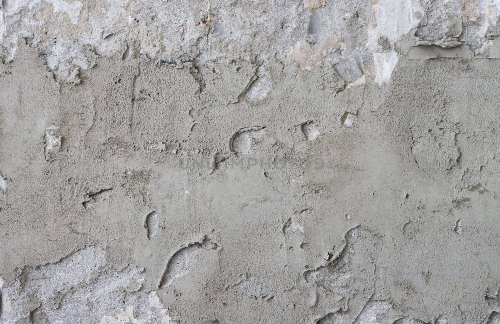 The wall is covered with rough putty. Cement wall covered with plaster.
