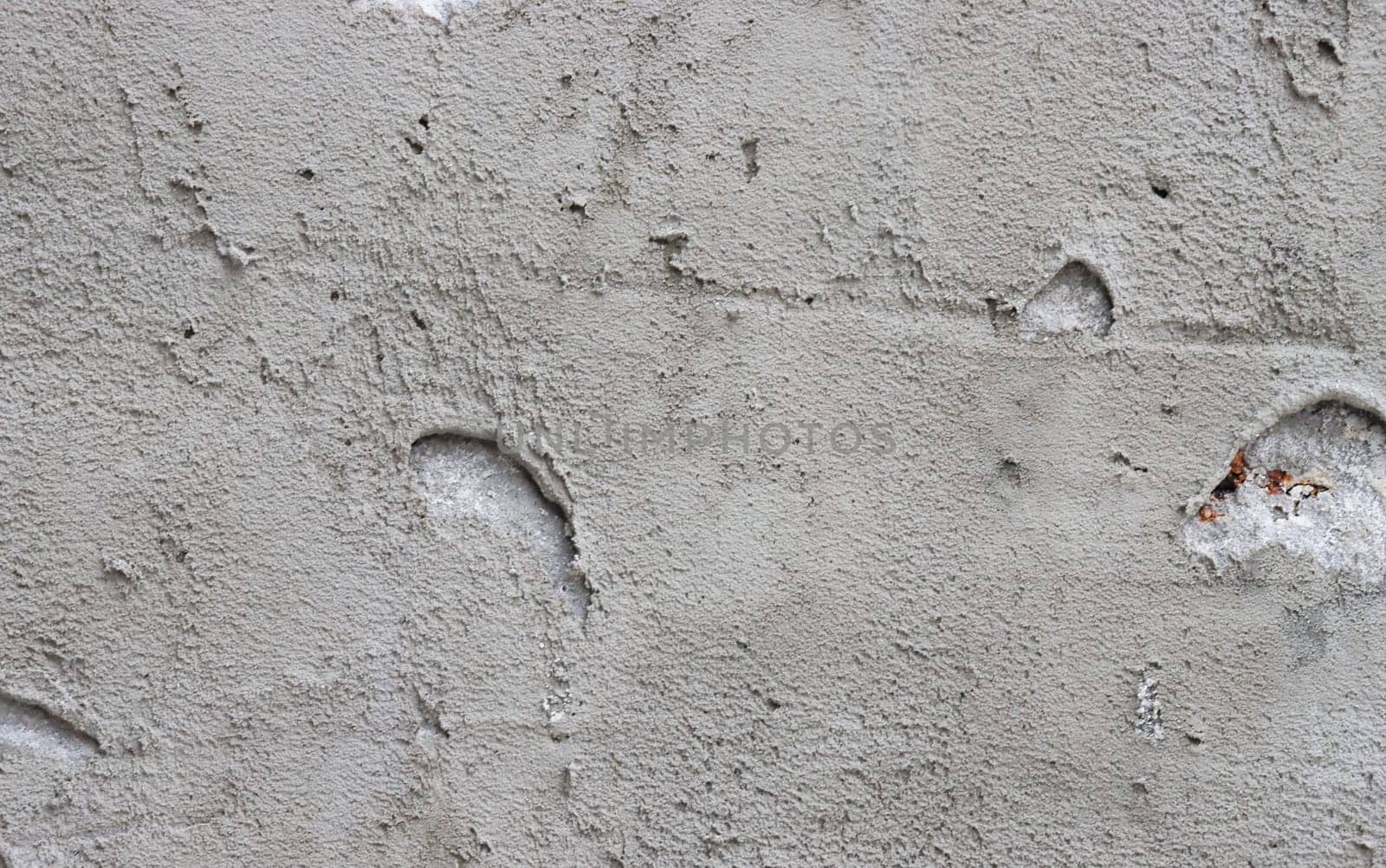 Abstract background from a wall covered with gray plaster.