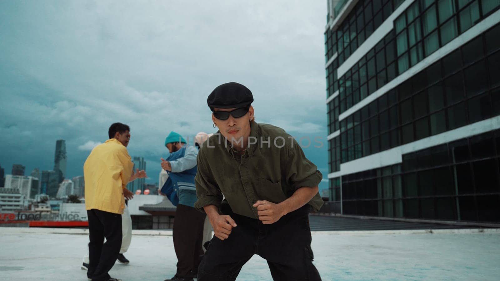 Professional asian dancer practice B boy dance while multicultural friends dancing at roof top. Young modern dancing group doing hip hop movement. Style,fashion,action. Outdoor sport 2024. Endeavor.