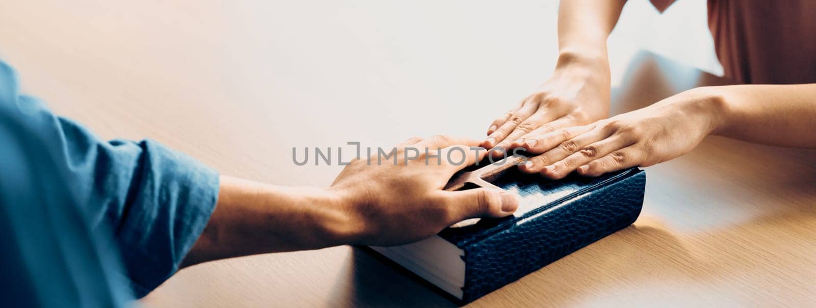 Close-up women prayer deliver holy bible book and holy cross to male believer. Spreading religion symbol. Concept of hope, religion, christianity and god blessing. Warm background. Burgeoning.