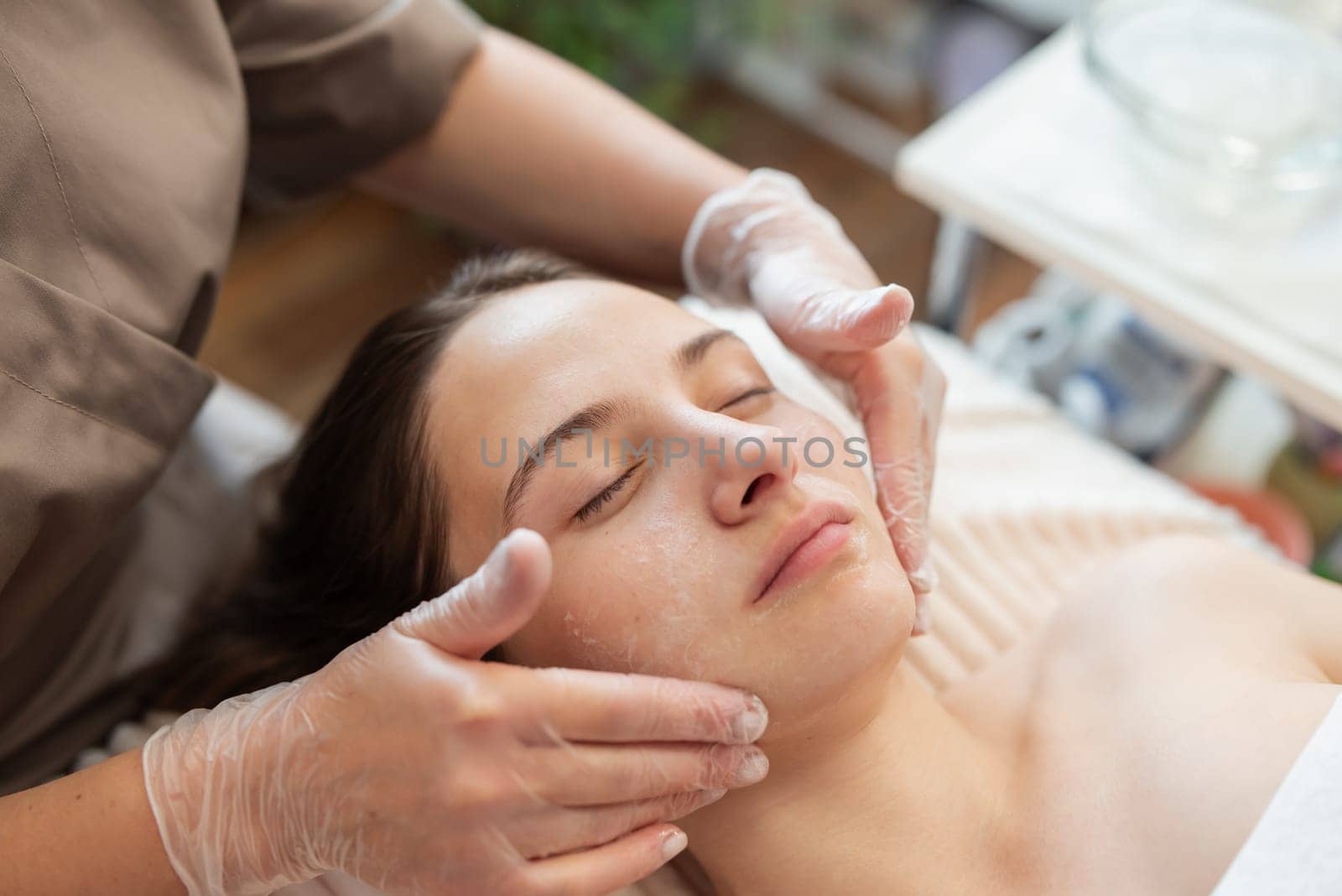 Preparations before ultrasonic face cleaning procedure on female face