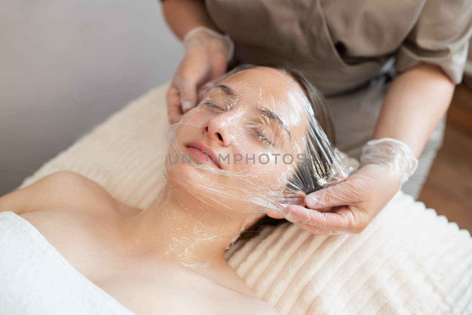 Cleaning face of a girl client with modern cosmetology techniques