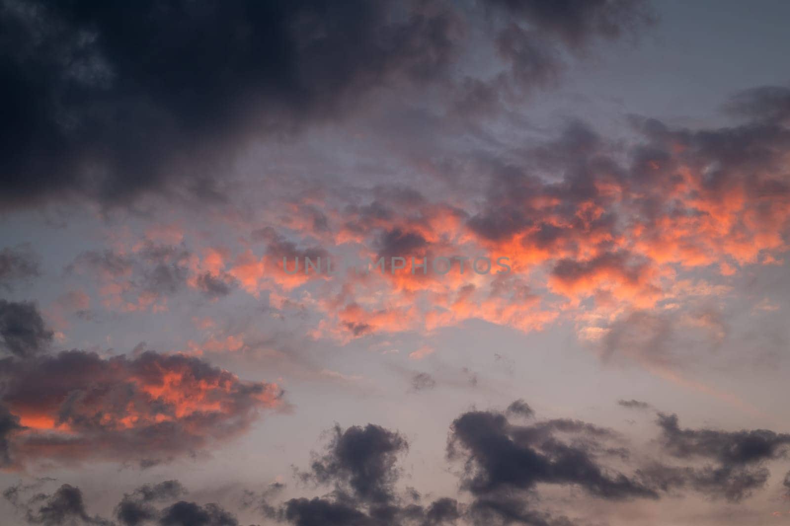 Vivid colors in burning sky after sunset, orange and dark blue clouds by VitaliiPetrushenko