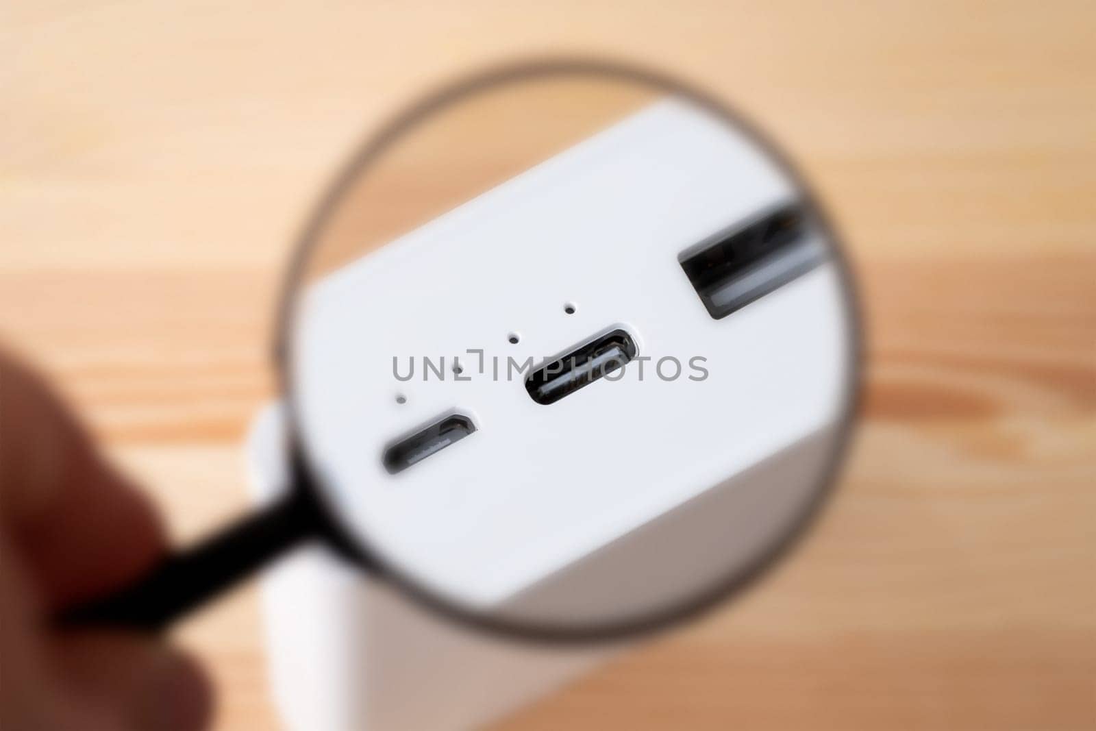 Magnifying glass on USB type c port of modern high capacity power bank by VitaliiPetrushenko
