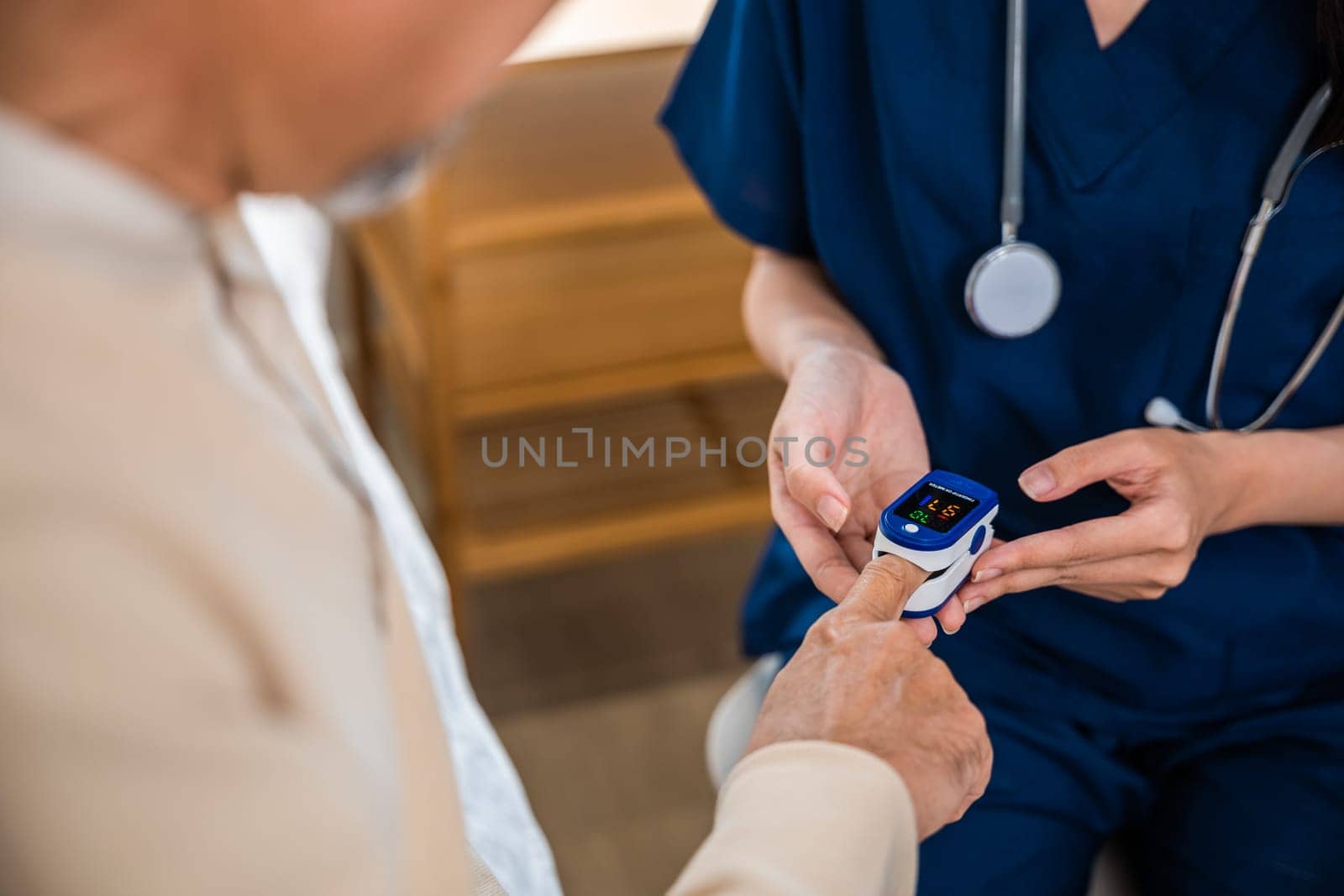 Young woman putting digital oximeter of finger middle aged adult patient for measurement, nurse checking with fingertip pulse oximeter oxygen meter blood monitor finger of senior old man at hospital