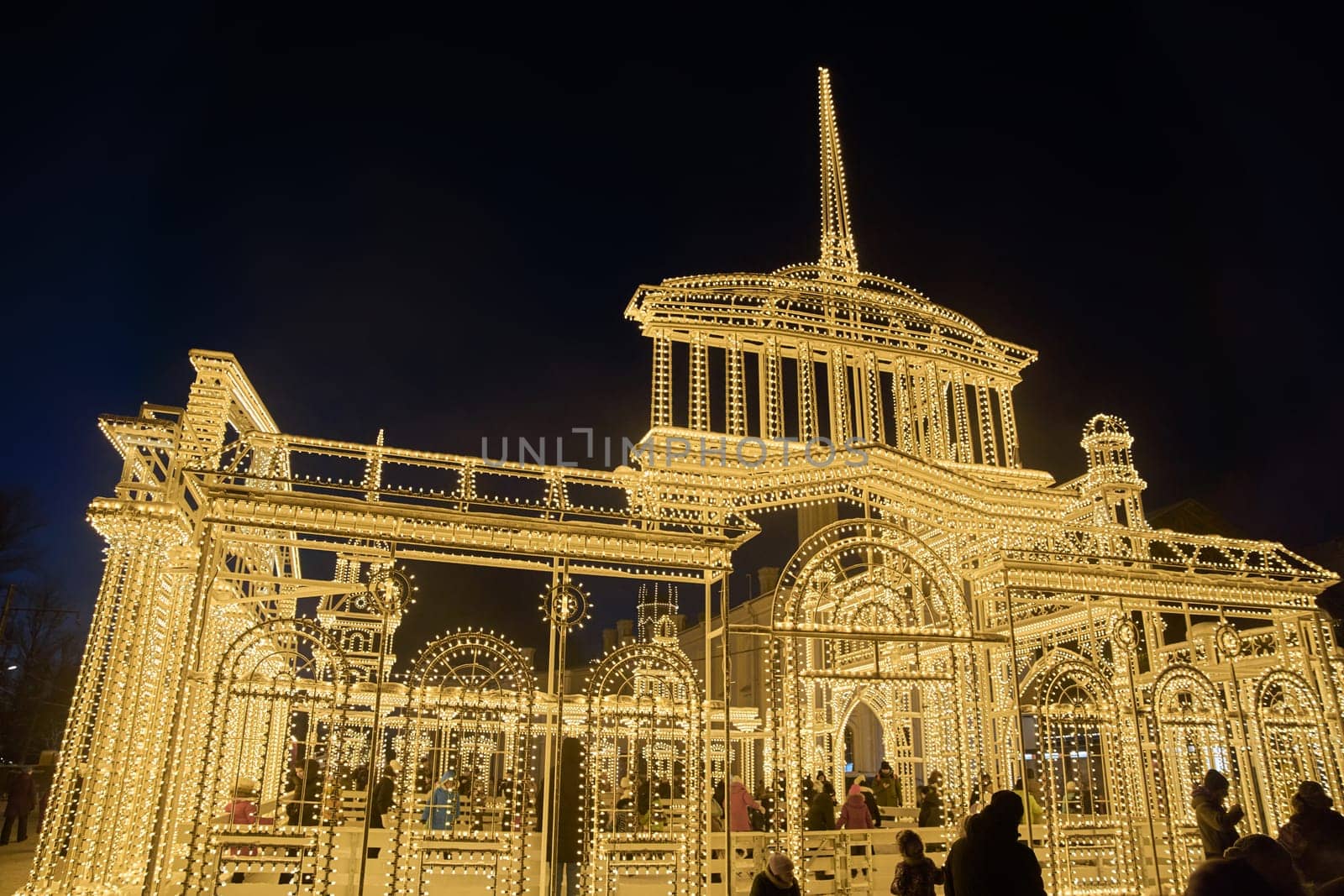 Russia, Peterhof, St.Petersburg, 07 January 2024: Magical illumination of the building of an ice rink decorated with light reliefs of the city's attractions, railway station, Christmas decorations by vladimirdrozdin